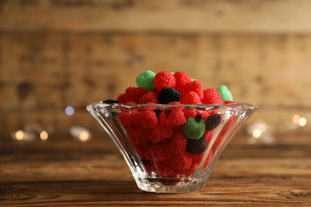 Delicious jelly candies in bowl on wooden table, closeupの写真素材