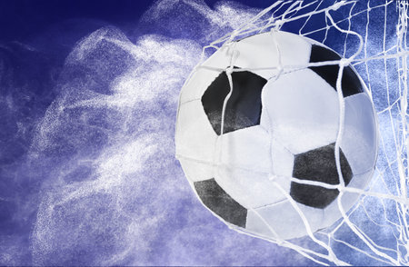 Soccer ball in net and white smoke on blue background, space for textの写真素材