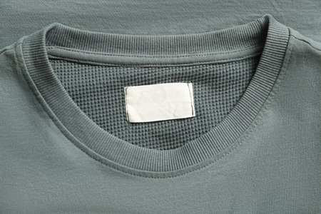Blank clothing label on gray sweater, top view