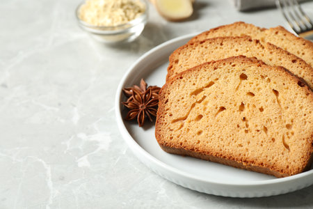 Slices of delicious gingerbread cake served on light gray table, closeup. Space for text