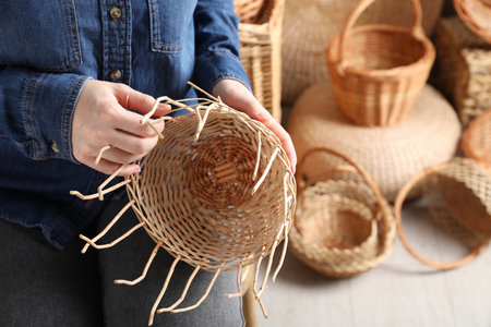 Woman weaving wicker basket indoors, closeup viewの写真素材