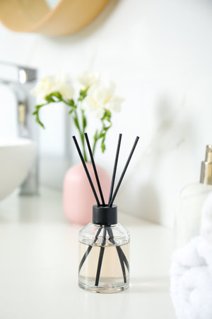 Aromatic reed air freshener on white countertop in bathroom