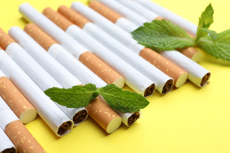 Menthol cigarettes and mint on yellow background, closeupの写真素材