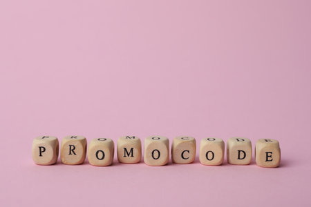 Word Promocode made of wooden cubes with letters on pink background, space for textの写真素材