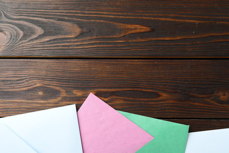 Colorful paper envelopes on wooden background, flat lay. Space for textの写真素材
