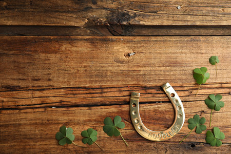 Clover leaves and horseshoe on wooden table, flat lay with space for text. St. Patrick's Day celebrationの写真素材