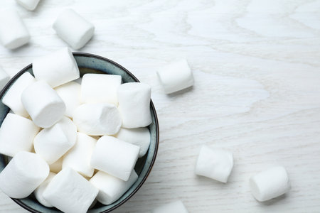 Delicious puffy marshmallows on white wooden tableの写真素材