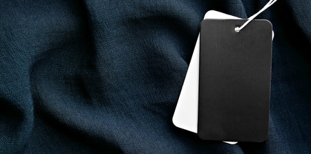 Blank tags on black fabric, top view with space for text. banner designの写真素材