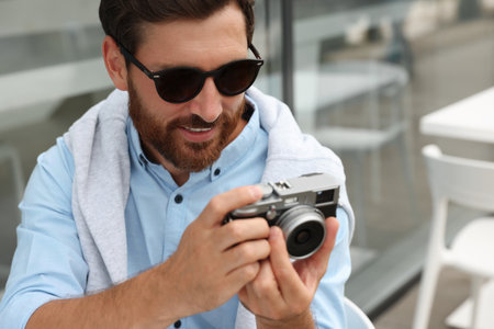 Man with camera in outdoor cafe. interesting hobby