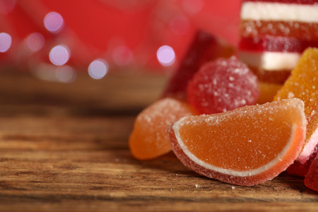 Delicious jelly candies on wooden table, closeup. Space for textの写真素材