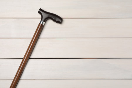 Elegant walking cane on white wooden table, top view. Space for textの写真素材