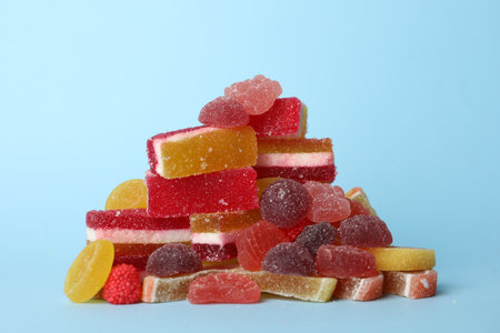 Pile of delicious bright jelly candies on light blue backgroundの写真素材