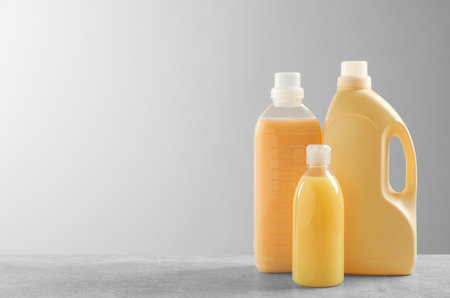 Different bottles with detergents on gray table, space for textの写真素材