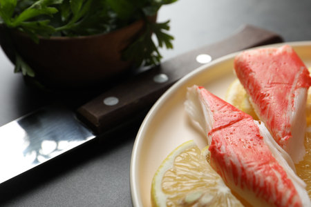 Delicious crab sticks with lemon slices on gray table, closeupの写真素材