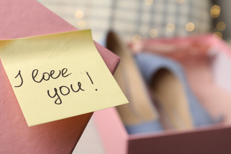 Note with phrase I Love You attached to cover of shoes box, closeup. Space for textの写真素材