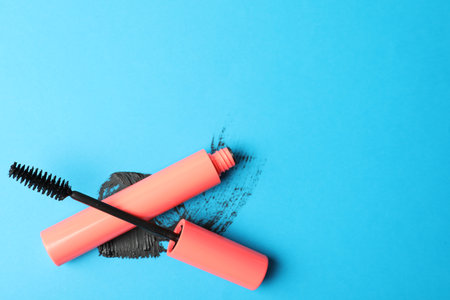 Mascara and smear on light blue background, flat lay with space for text. makeup productの写真素材