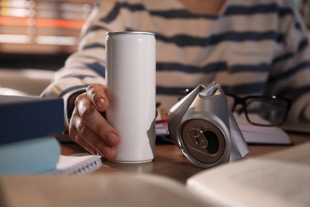 Young woman with energy drink studying at home, closeup
