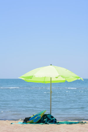 Light green beach umbrella in sand near sea on sunny dayの写真素材