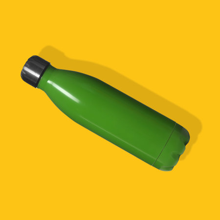 Green sports water bottle on yellow background, top viewの写真素材