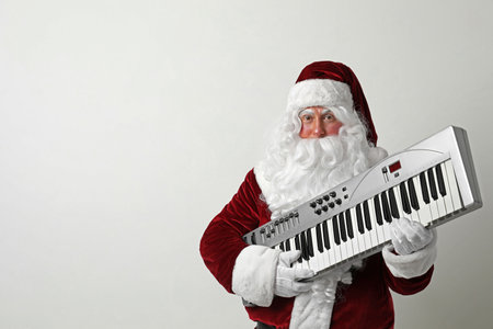Santa Claus with synthesizer on light background, space for text. christmas musicの写真素材