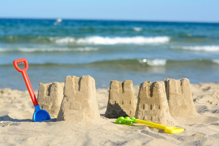 Beautiful sand castles and child plastic toys on the beach near the seaの写真素材