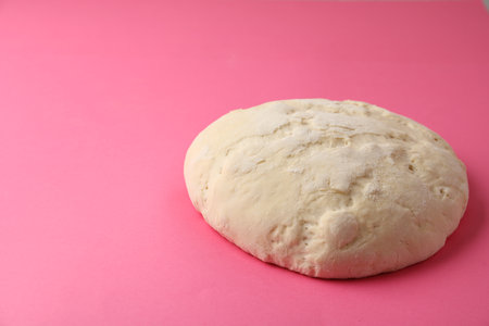 Raw dough for pastries on pink background. Space for textの写真素材