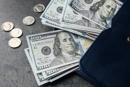 Dollar banknotes, coins and wallet on gray table, closeup. money exchange