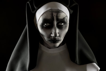 Portrait of scary devilish nun on black background. halloween party lookの写真素材