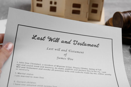 Woman holding last will and testament at gray table, closeupの写真素材