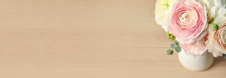Beautiful ranunculus flowers in vase on wooden table, space for text. banner design