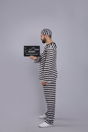 Prisoner in special uniform with mugshot letter boardの写真素材