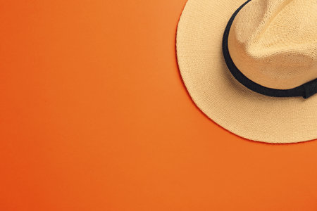 Stylish straw hat on orange background, top view. Space for textの写真素材