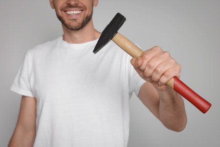 Happy worker holding hammer on white background, closeupの写真素材