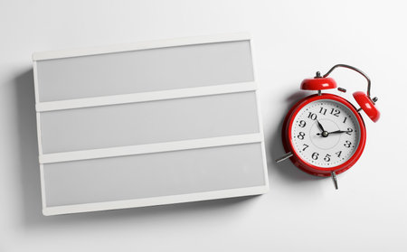 Blank letter board and alarm clock on white background, flat lay