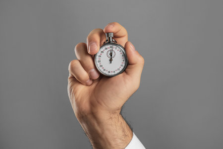 Man holding vintage timer on gray background, closeupの写真素材