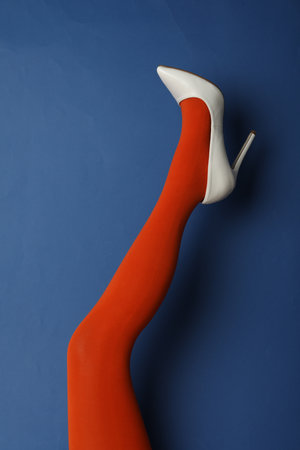 Woman wearing bright tights and high heel shoe on blue background, closeupの写真素材