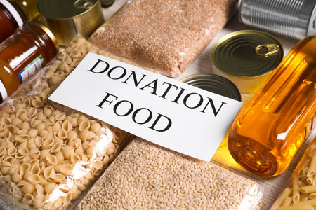 Card with words Donation Food and different products on white table, closeupの写真素材