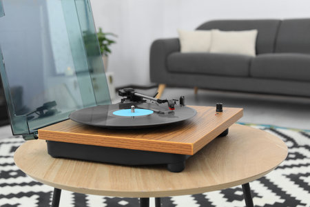 Vinyl record player on wooden table indoors. interior element