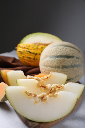 Tasty colorful ripe melons on light gray table