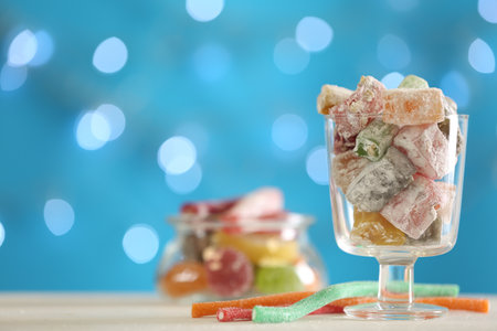 Delicious lokum on light table against blurred lights. Space for textの写真素材