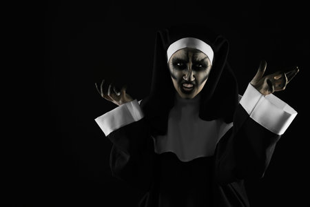 Portrait of scary devilish nun on black background, space for text. halloween party lookの写真素材