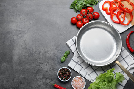 Flat lay composition with frying pan and fresh products on gray table, space for textの写真素材
