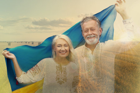 Double exposure of happy mature couple with national flag of Ukraine and wheat fieldの写真素材