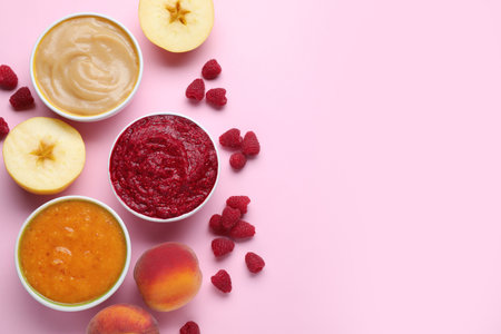 Different puree in bowls and fresh ingredients on pink background, flat lay. Space for textの写真素材