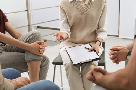 Psychotherapist working with group of drug addicted people at therapy session indoors, closeupの写真素材