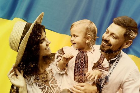 Double exposure of happy family wearing national clothes and Ukrainian flagの写真素材