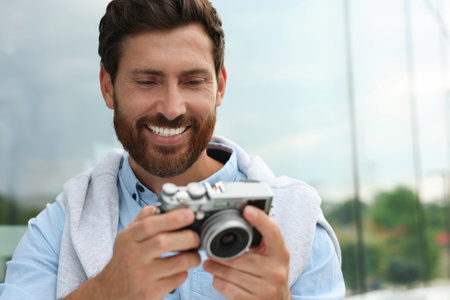 Man with camera outdoors, space for text. interesting hobby