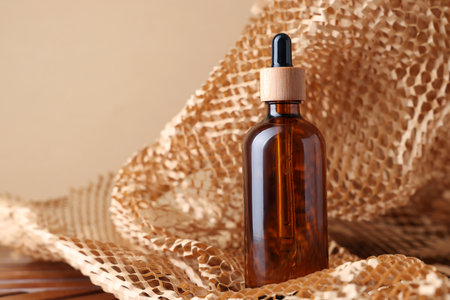 Glass bottle of cosmetic product on dark beige background, space for textの写真素材