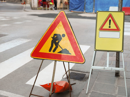 Different traffic signs near pedestrian crossing on city streetの写真素材
