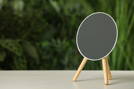 Stylish round mirror on white table against blurred background. Space for textの写真素材